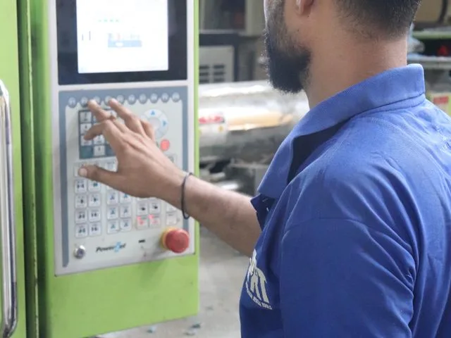 Élelmiszeripari csomagológép kezelő a gép vezérlőpaneljét kezeli